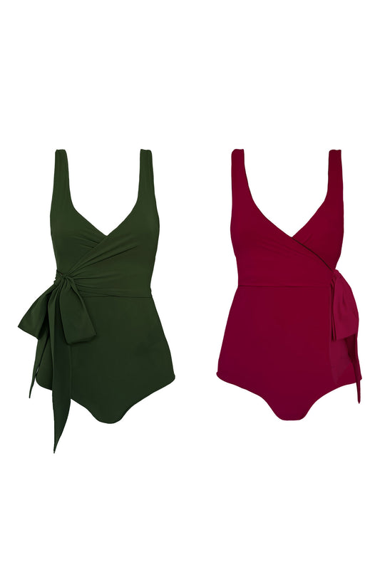Product image showing wrap swimsuits in both reversible colours, a solid deep green on the left and it's other raspberry pink side on the right.