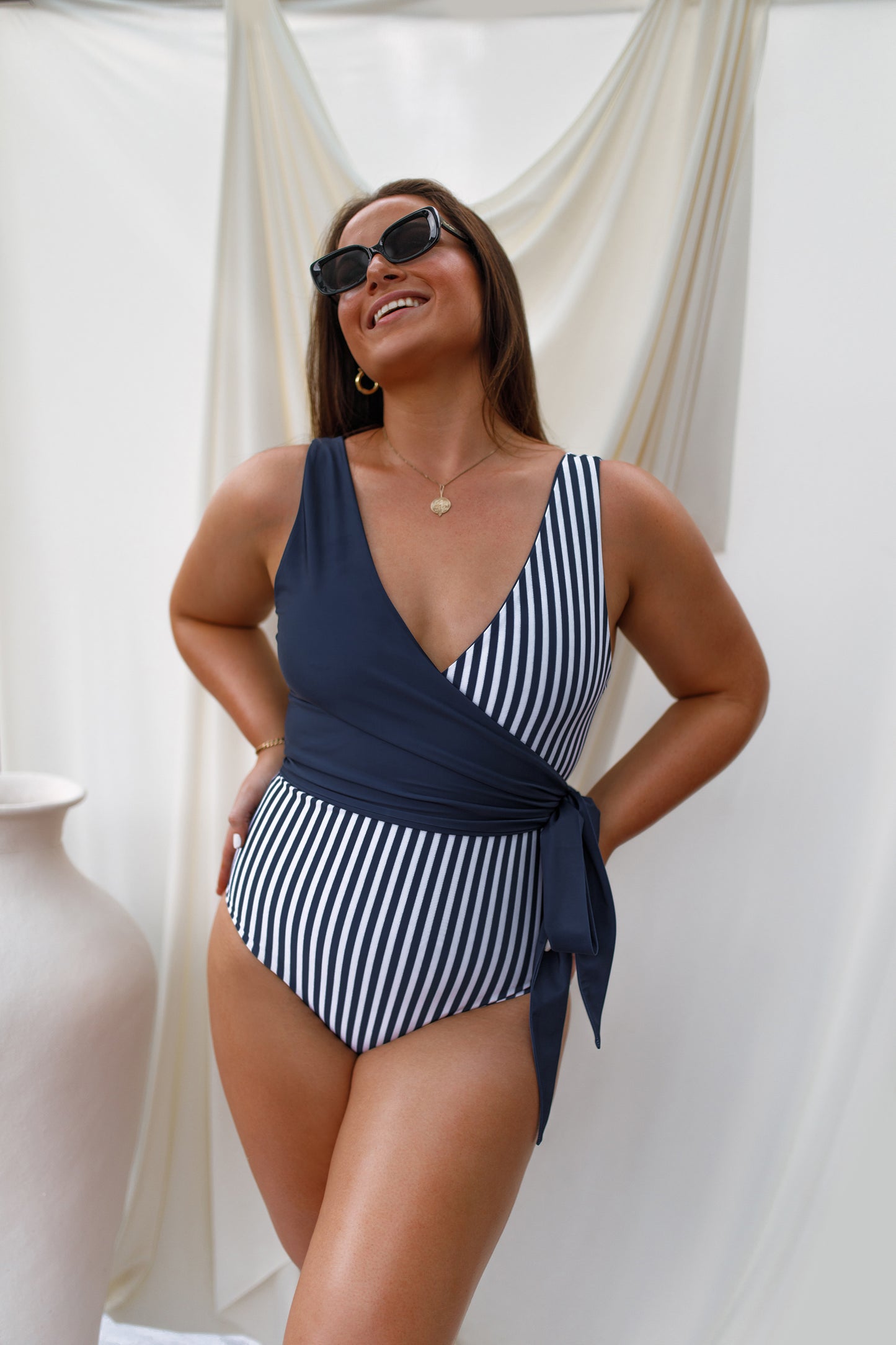 smiling woman in navy one piece swimsuit
