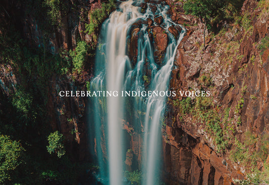 Waterfall cascading down red rock cliff face.