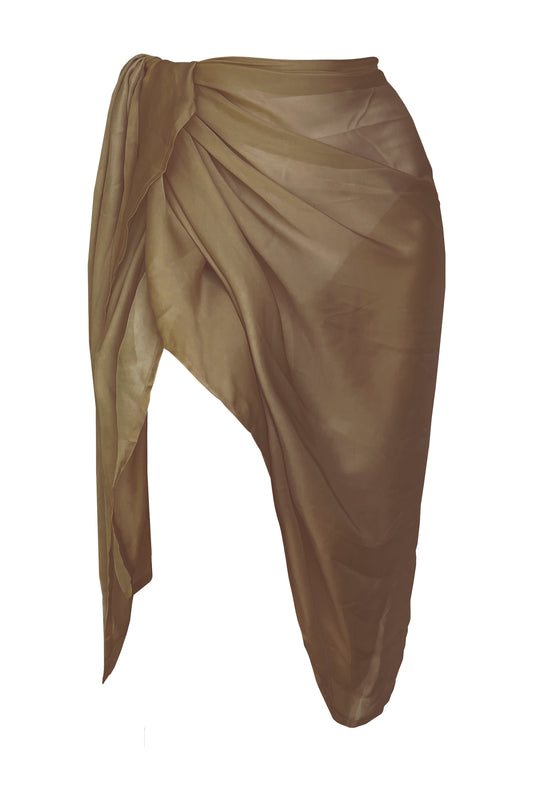 Woman standing on the sea shore dressed in the Barcelona bikini top paired with the Barcelona khaki sarong.