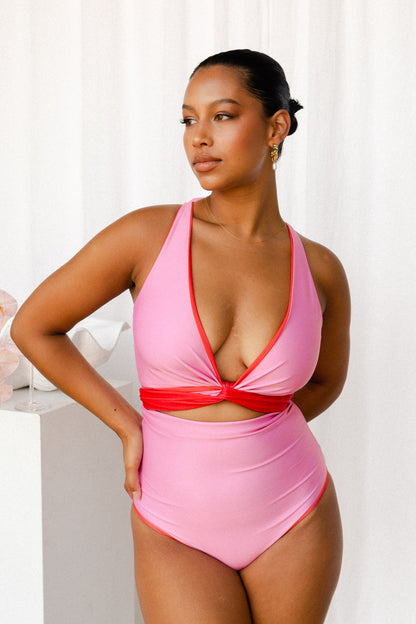 Woman wears a bikini set with a red tie used to cinch the bust and create a V-neck.