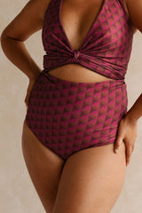 Woman wearing a burgundy bikini set with a geometric jewelled pattern.