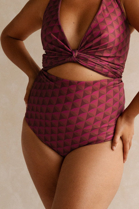 Woman wearing a burgundy bikini set with a geometric jewelled pattern.