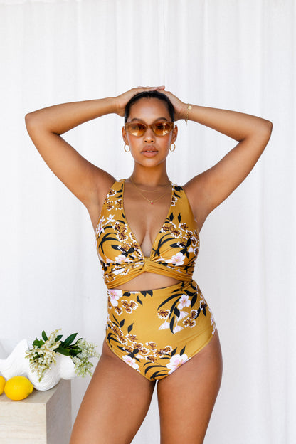 Woman wearing mustard floral bikini.