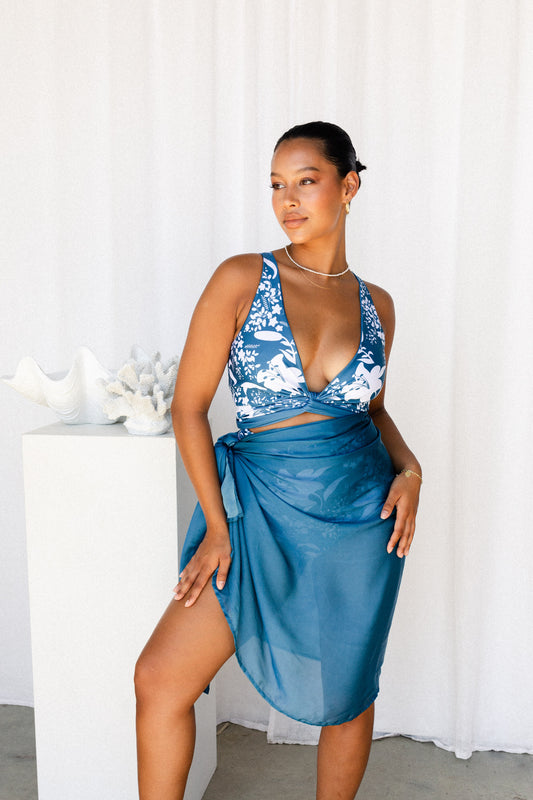 Woman poses in blue sarong and bikini