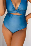 Woman wearing solid ocean blue bikini set holds a white star fish ornament.