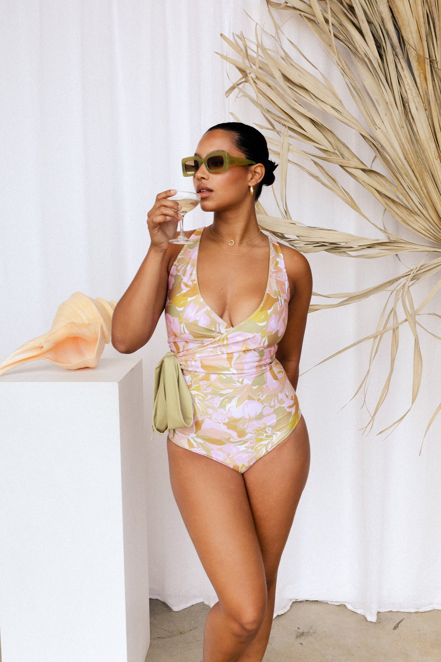 Woman in solid floral swimsuit with tie as large bow at waist