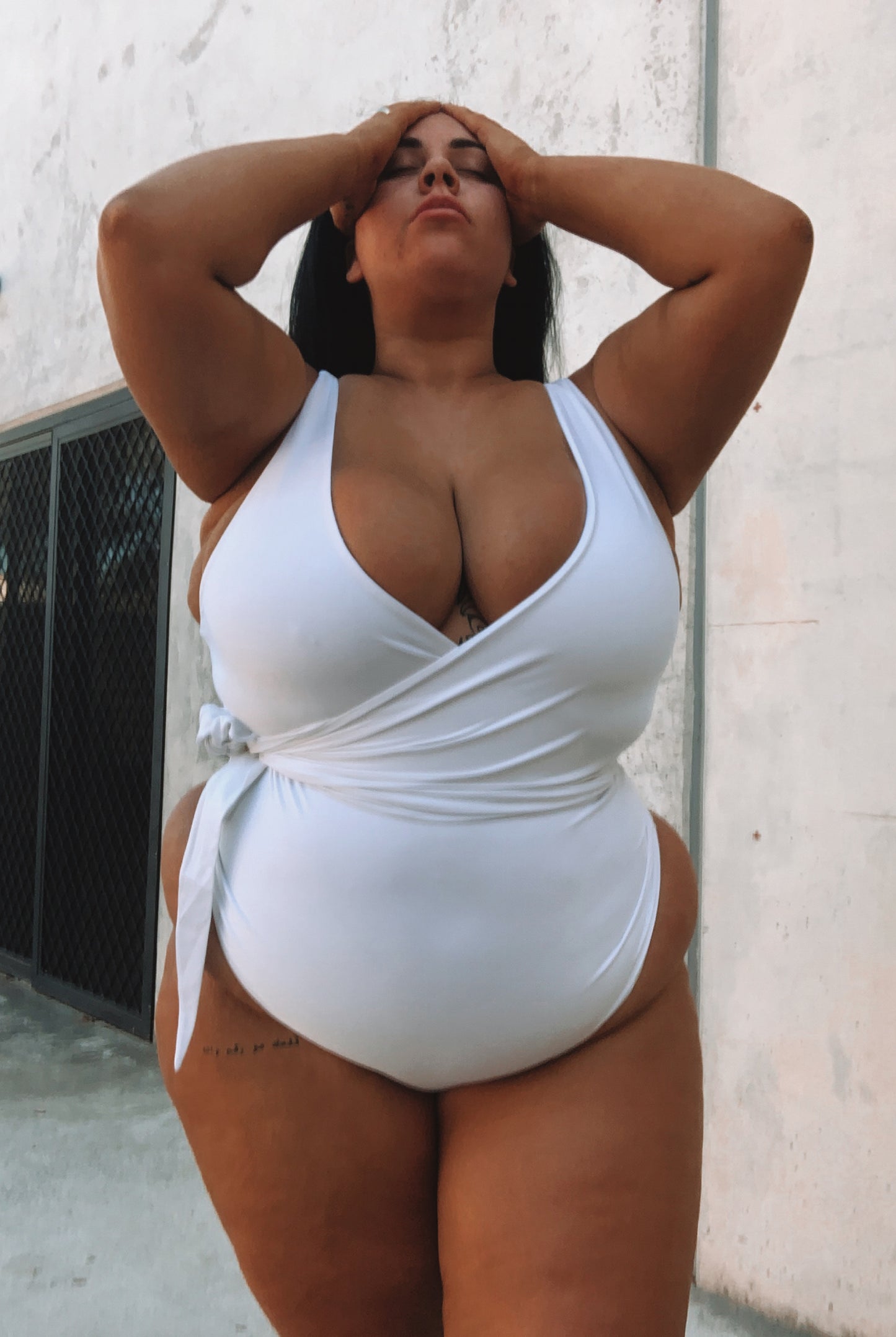 woman wearing white swimsuit with tie cinching waist 