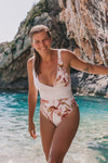 Woman wearing white swimsuit with banksia print without tie.