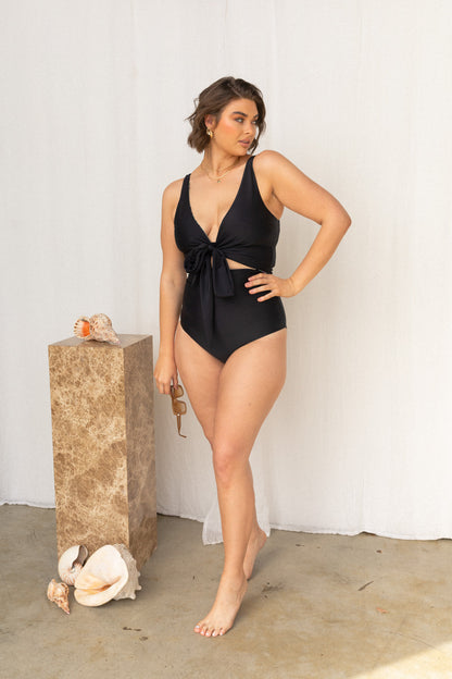 Woman poses with black reversible bikini