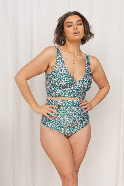 Woman wearing a jasmine green, pink, white and gold confetti print bikini set.