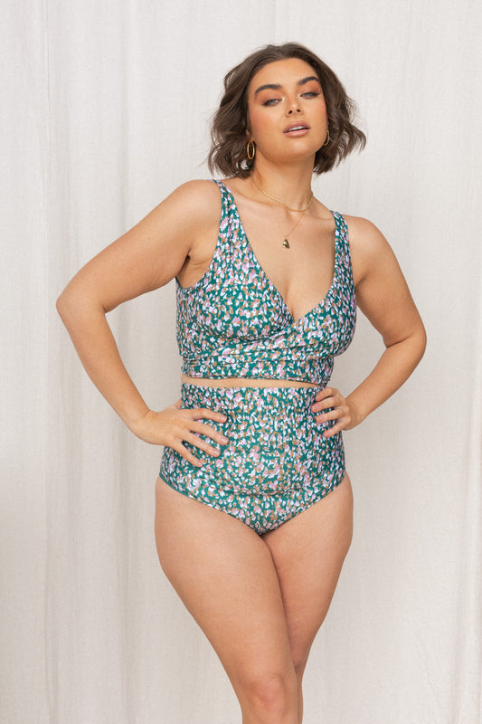 Woman wearing a jasmine green, pink, white and gold confetti print bikini set.